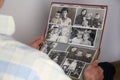 ManÃ¢â¬â¢s hands of an old man holding an old retro album with vintage monochrome photographs in sepia color, the concept of Royalty Free Stock Photo